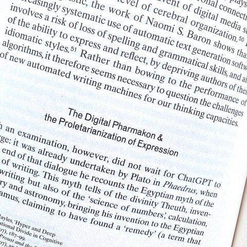 A close-up of printed text from a book or article, showing a section titled 'The Digital Pharmacist & The Proletarianization of Expression' on a white page.